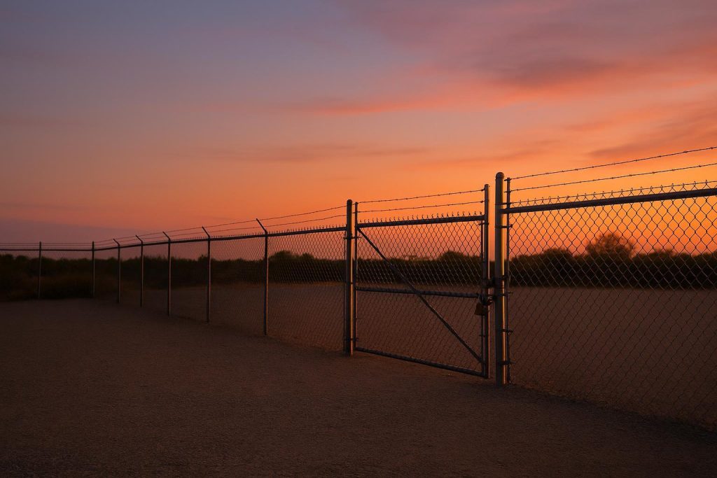 Secure gravel facility with a locked gate indicating after business hours access.